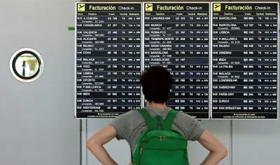 Un pasajero comprueba un panel de información sobre vuelos en la terminal 4 del aeropuerto Adolfo Suárez-Barajas en Madrid, en una imagen de archivo. 