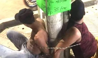 Los dos hombres atados en el poste.