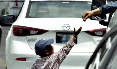 Mientras los niños se exponen a recibir el dinero, sus padres aguardan cerca para recibir la ganancia. 