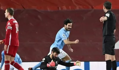 Ilkay Guendogan celebra ante la lamentación de Alisson. 