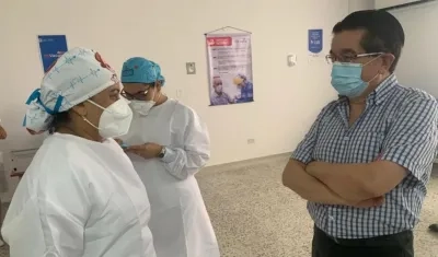 La enfermera jefe Verónica Machado, derecha, dialoga con el ministro de Salud, Fernando Ruiz.