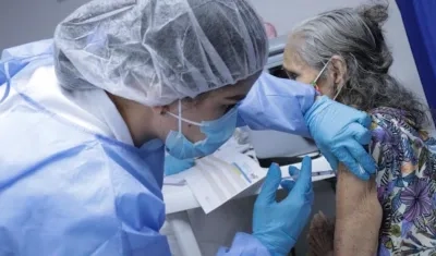 Aplicación de la vacuna a uno de los adultos mayores.