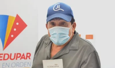 Poncho Zuleta muestra su carnet de vacunación.