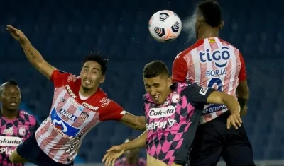 Fabián Sambueza y Miguel Ángel Borja disputan el balón con un jugador de santa Fe. 
