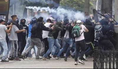 Un grupo de manifestantes arremetiendo contra la Fuerza Pública en Medellín.