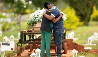 Un grupo de personas asiste al entierro de un ser querido víctima de covid-19 hoy, en el cementerio Campo da Esperança, en la ciudad de Brasilia (Brasil).