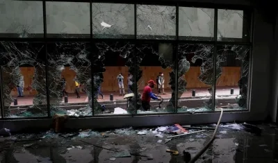 Manifestantes destruyen locales comerciales y bancarios durante las protestas contra la reforma tributaria.