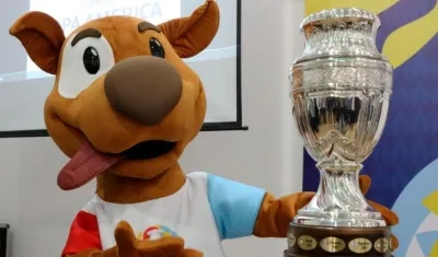 'Pibe', la mascota del torneo, al lado del trofeo de la Copa América. 