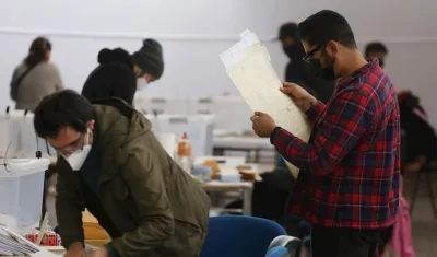 Varias personas sufragan en un puesto de votación hoy, en Santiago (Chile).
