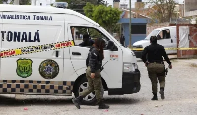 Policías municipales resguardan el área acordonada de una fosa clandestina en Jalisco, México.