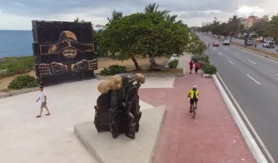 Personas pasan junto al monumento a los "Héroes del 30 de mayo".