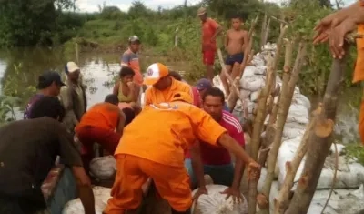 Los organismos de socorro y la comunidad se encuentran en el lugar donde podría desbordarse el río. 