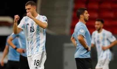 Guido Rodríguez celebra su gol, ante los lamentos de Luis Suárez. 