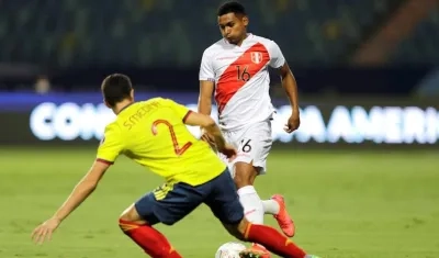 Stefan Medina disputando el balón con el peruano Marcos López.