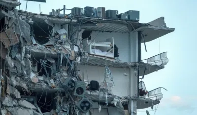  Unas ochenta unidades entre vehículos de los servicios de rescate y bomberos buscan entre los escombros posibles víctimas del derrumbe parcial del edificio.