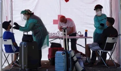 Varios trabajadores de Cruz Roja realizan una prueba PCR a un joven en Valladolid.