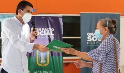El alcalde Rodolfo Ucrós entregando uno de los títulos de propiedad. 