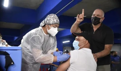 El COO Christian Daes observa al primer trabajador de Tecnoglass vacunado.