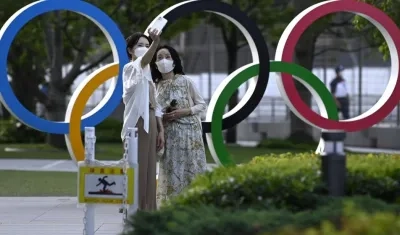 Ciudadanas de Tokio se toman fotografías en los aros olímpicos. 