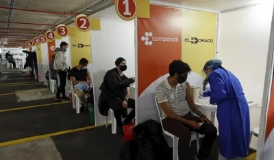 Personal médico vacuna hoy contra el Covid-19 a trabajadores de empresas privadas, en el Aeropuerto Internacional El Dorado de Bogotá (Colombia). 