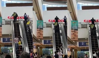 Los dos ladrones, uno vestido de policía, cuando bajaban corriendo por la escalera eléctrica del centro comercial. 