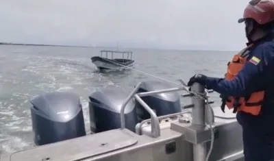 Miembros de Guardacostas de la Armada llevan la lancha recuperada.