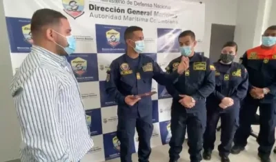 Daniel Pereira de la Oficina de Desarrollo de Puerto Colombia entrega el reconocimiento al capitán de fragata Carlos Urbano Montes, de la Dimar.