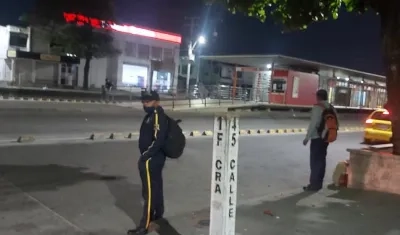 Estación de Transmetro desolada y usuarios esperando transporte.