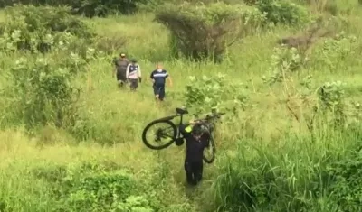 Momento en que traen la bicicleta que fue abandonada por los ladrones en el monte. 