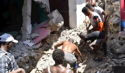 Un grupo de personas remueve escombros tras el terremoto en Haití.