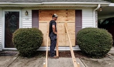 Kirby Plaisance ayuda a asegurar la casa de sus padres mientras se preparan para la llegada del huracán Ida en St. Charles Parish, Louisiana.