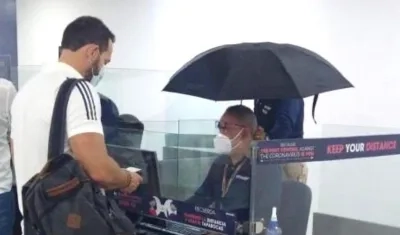 Funcionarios de Migración Colombia protegiéndose de las goteras dentro del mismo aeropuerto.