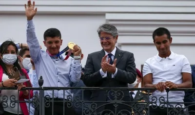 El ciclista ecuatoriano Richard Carapaz muestra su medalla olímpica, acompañado del presidente de Ecuador Guillermo Lasso (c) y del ciclista Jhonatan Narváez.