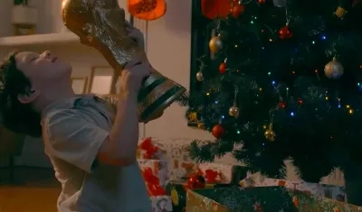 La imagen del niño con la réplica del trofeo de los campeones mundiales.