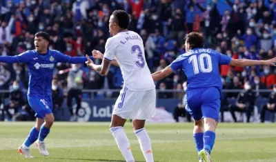 Militao protesta tras u error, mientras celebran los jugadores del Getafe. 