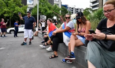 Aficionados de Novak Djokovic lo acompañan desde las afueras.