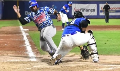 Carlos Martínez anota en jugada cerrada en el home. 