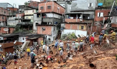 Bomberos y voluntarios trabajan en el área de un deslizamiento de tierra provocado por fuertes lluvias, en Sao Paulo, Brasil.