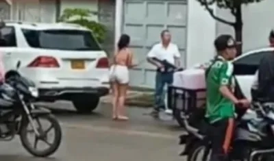 Julio César Yamin Berardinelli, con fusil en mano, discute con los ocupantes de un automóvil blanco.