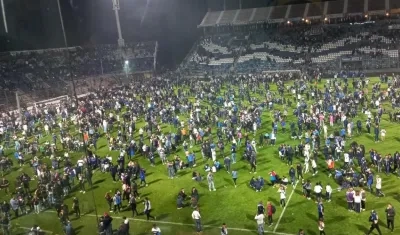 Hinchas en el terreno de juego de la cancha de Gimnasia y Esgrima de La Plata.