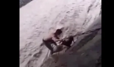 Félix Alvarado sujeta al perro con una cuerda.