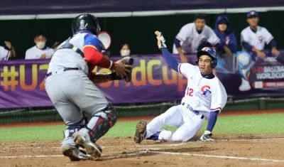 Un corredor de Taipéi anota ante el cátcher colombiano. 