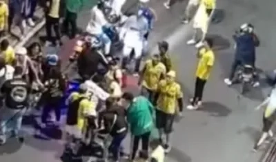 Varias personas auxilian al hincha del Atlético Bucaramanga herido a bala.