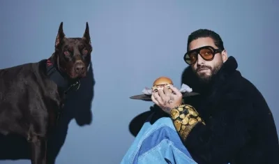 Maluma rodeado de hamburguesas y hot dogs (perros calientes).