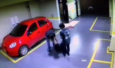 Después de la golpiza en el ascensor, el periodista y un amigo arrastran a la mujer en un parqueadero.