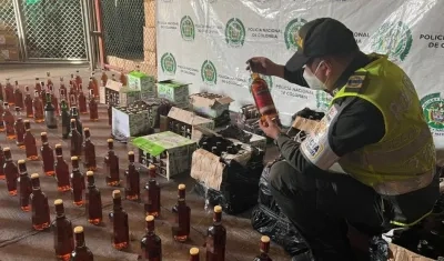 Un policía revisando el licor adulterado. 
