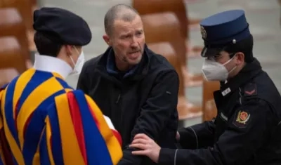 El hombre es escoltado por dos agentes después de increpar al papa Francisco.