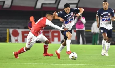 Fabián Sambueza intentando eludir la marca santafereña.