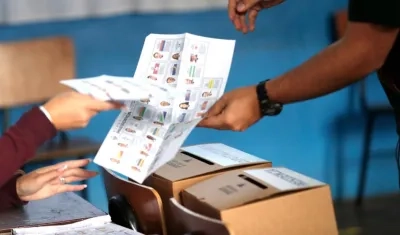 Un ciudadano depositando en la urna el tarjetón presidencial.