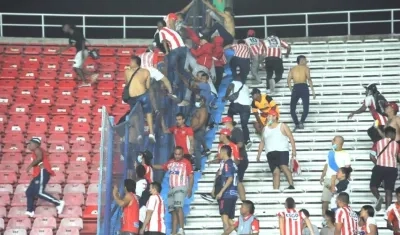 Hinchas invadiendo las tribunas vecinas para protagonizar el vandalismo.
